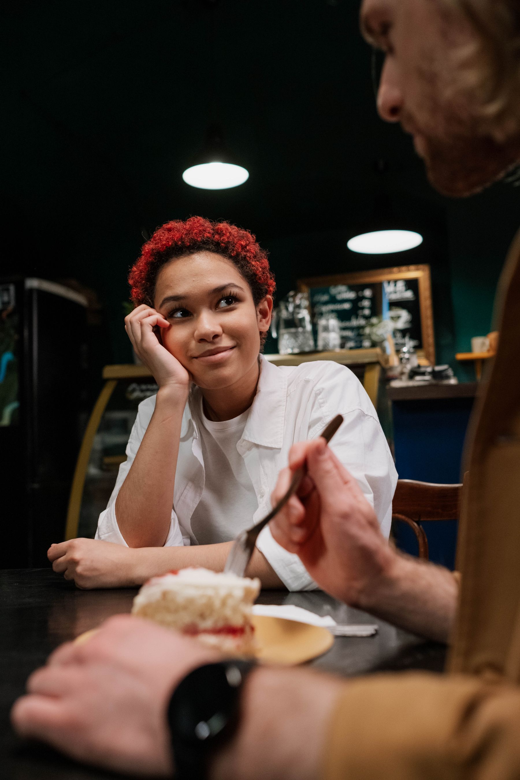 A woman and a man laughing on a date in a café